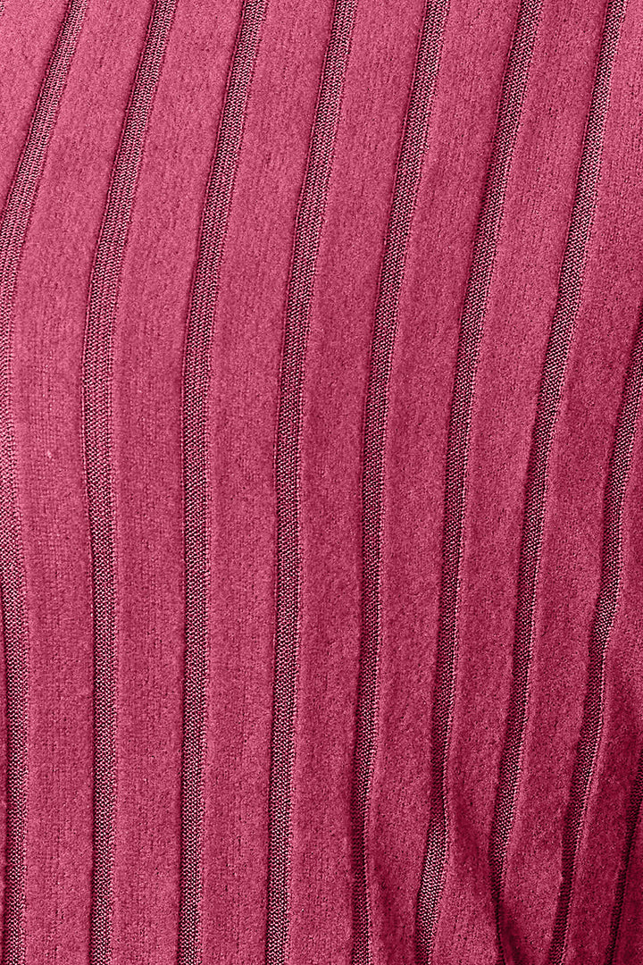 A detailed view of the Basic Bae Full Size Ribbed Cocoon Cardigan showcases its slightly stretchy red fabric with vertical stripes. The textured polyester material displays varying shades of red, accentuated by thin, dark lines that form a simple ribbed pattern.