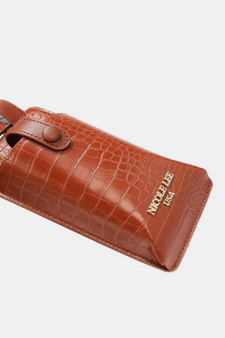 The Nicole Lee USA 2 Piece Texture Belt Bag features brown, crocodile-patterned vegan leather with a buttoned strap and gold embossed NICOLE LEE USA logo on the front.