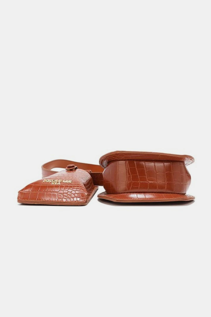 The Nicole Lee USA 2 Piece Texture Belt Bag, a small structured brown vegan leather crossbody with a crocodile pattern, is displayed from two angles—upright with logo and laying flat—set against a plain white background.