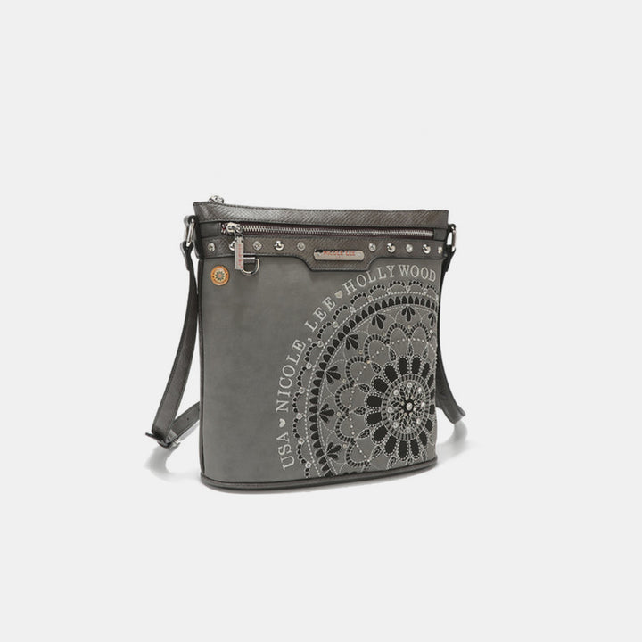 The Nicole Lee USA Metallic Stitching Embroidery Inlaid Rhinestone Crossbody Bag is crafted from gray vegan leather, showcasing a front mandala pattern and USA NICOLE LEE HOLLYWOOD text. It features a zippered top, adjustable strap, and silver-tone hardware for elegance.