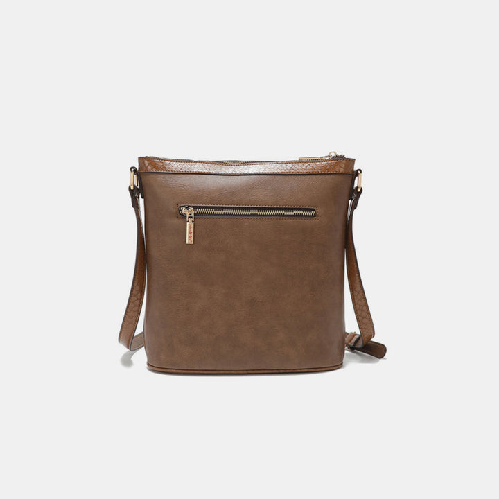 The Nicole Lee USA Crossbody Bag combines metallic stitching and rhinestone detailing with a vegan leather finish. It features an adjustable strap, top zipper closure, and a zippered front pocket, offering a stylish and functional design perfect for everyday use.