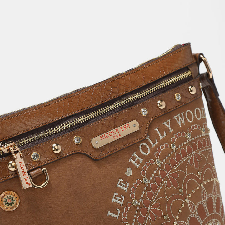 The Nicole Lee USA Metallic Stitching Embroidery Inlaid Rhinestone Crossbody Bag is brown, made from vegan leather, and features floral patterns, decorative studs, a zipper, hanging tag, and label on a white background.