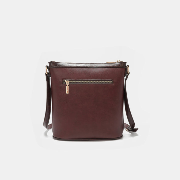 The Nicole Lee USA Metallic Stitching Embroidery Inlaid Rhinestone Crossbody Bag is crafted from brown vegan leather featuring rhinestones, a zippered front pocket, and an adjustable shoulder strap, displayed against a plain white background.