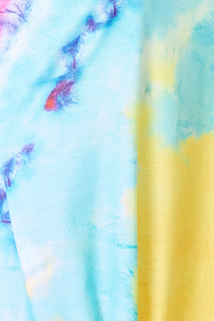 Close-up of the vibrant Shiny Tie-Dye V-Neck Twisted Dress fabric, showcasing an abstract blend of blue, yellow, purple, and red shades.